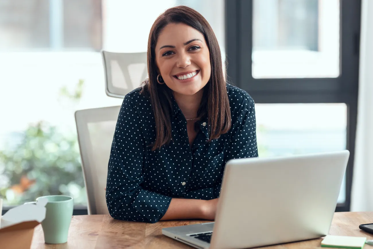 A woman smiling while using the CompHub software